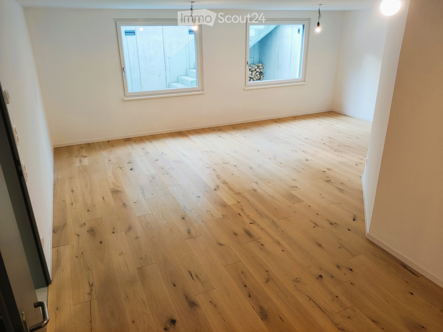 empty room, wooden floor, two windows, white walls, two lamps hanging