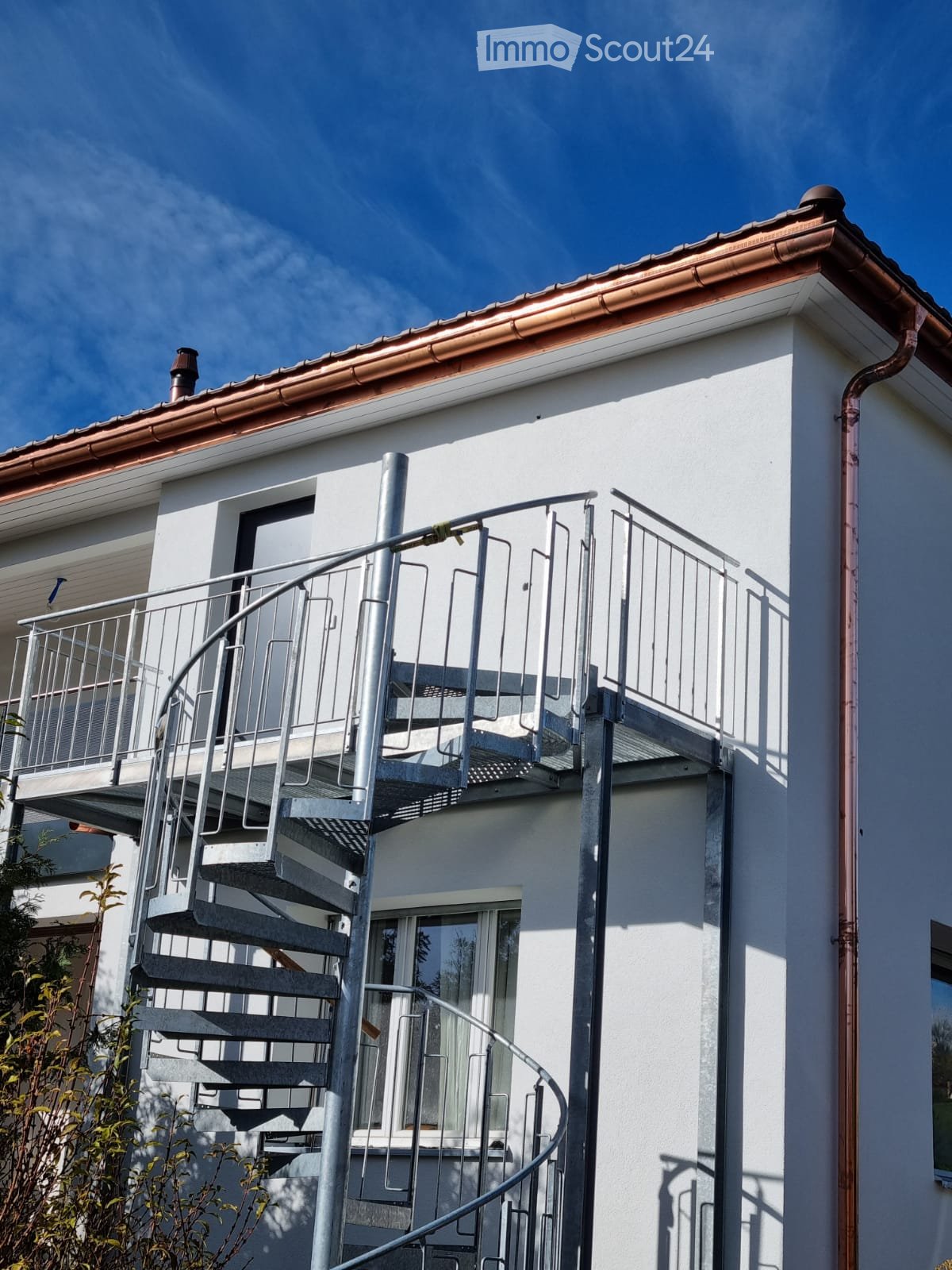 white building, spiral stairs, metal railing, copper roof, window with glass panel