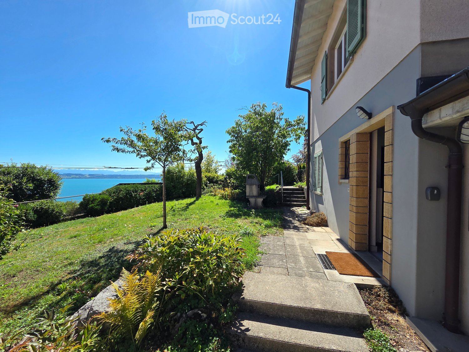 House with garden, steps leading to the entrance, overlooking the sea and mountains.