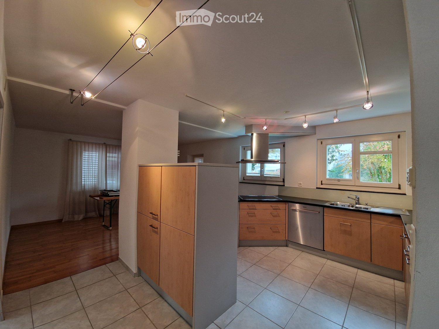 Kitchen with wooden cabinets, countertop, sink, faucet, dishwasher, oven.