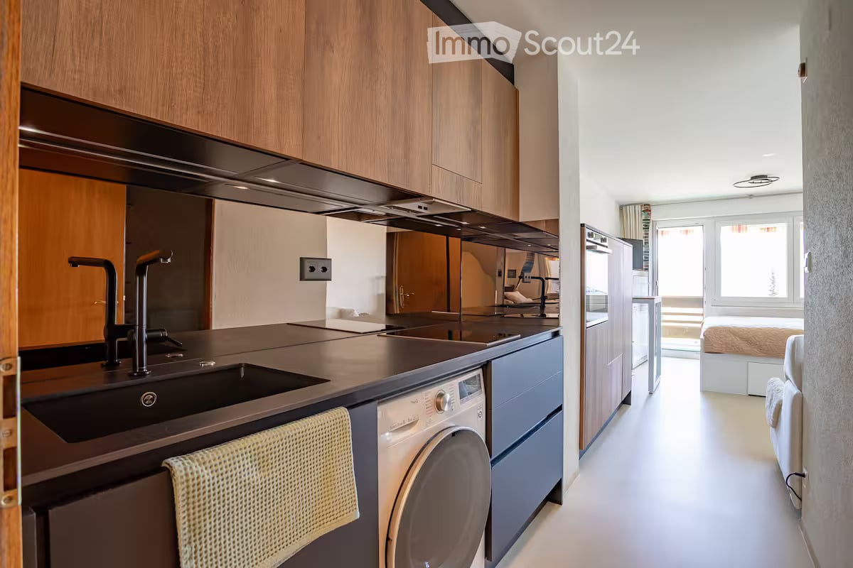 modern kitchen, wooden cabinets, black countertops, double sinks, washing machine