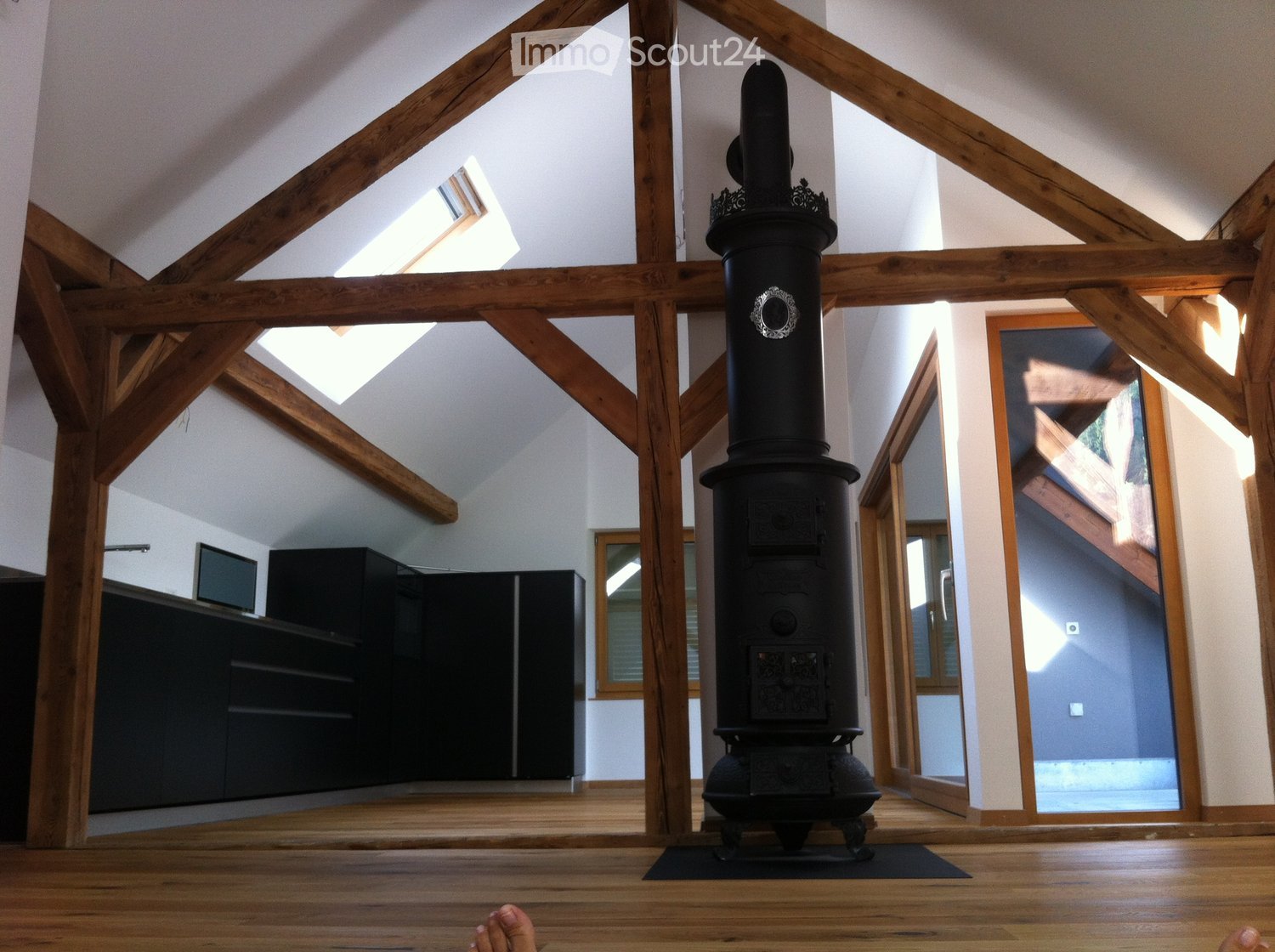 wooden beams, fireplace, black stove, white walls, wooden floors