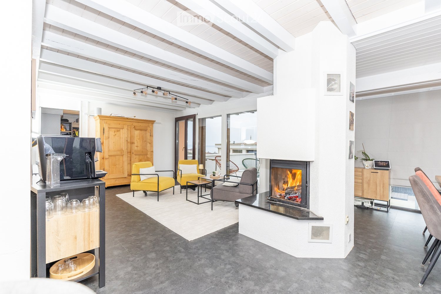 modern interior, exposed wooden ceiling, fireplace, yellow chairs, white rug, glass windows