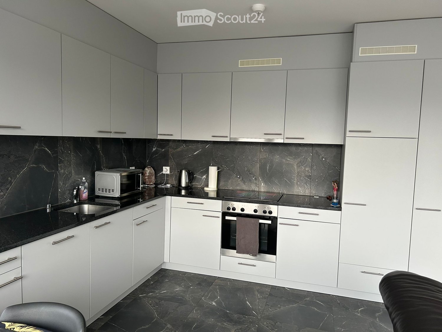 modern kitchen with marble counter top, oven, microwave, dishwasher, and washing machine