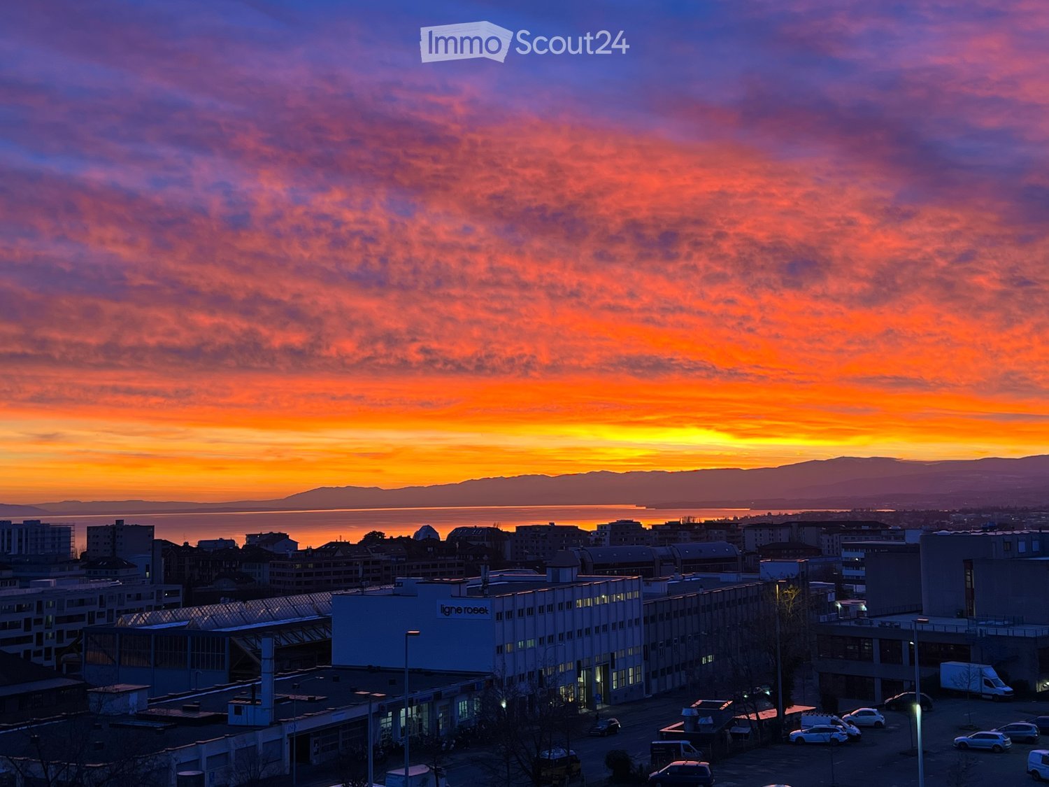 Cityscape, sunset, buildings, parking lot, streetlights, mountains, horizon, buildings
