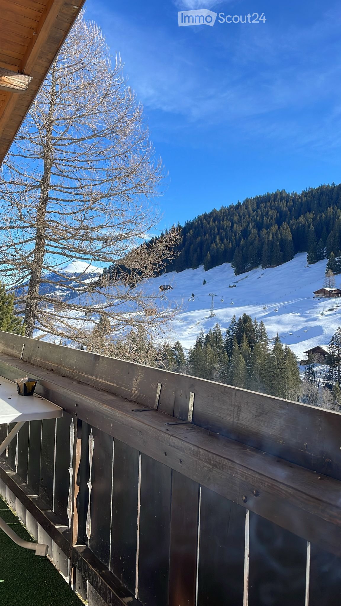 Balcony with railing and table with view of snowy mountains