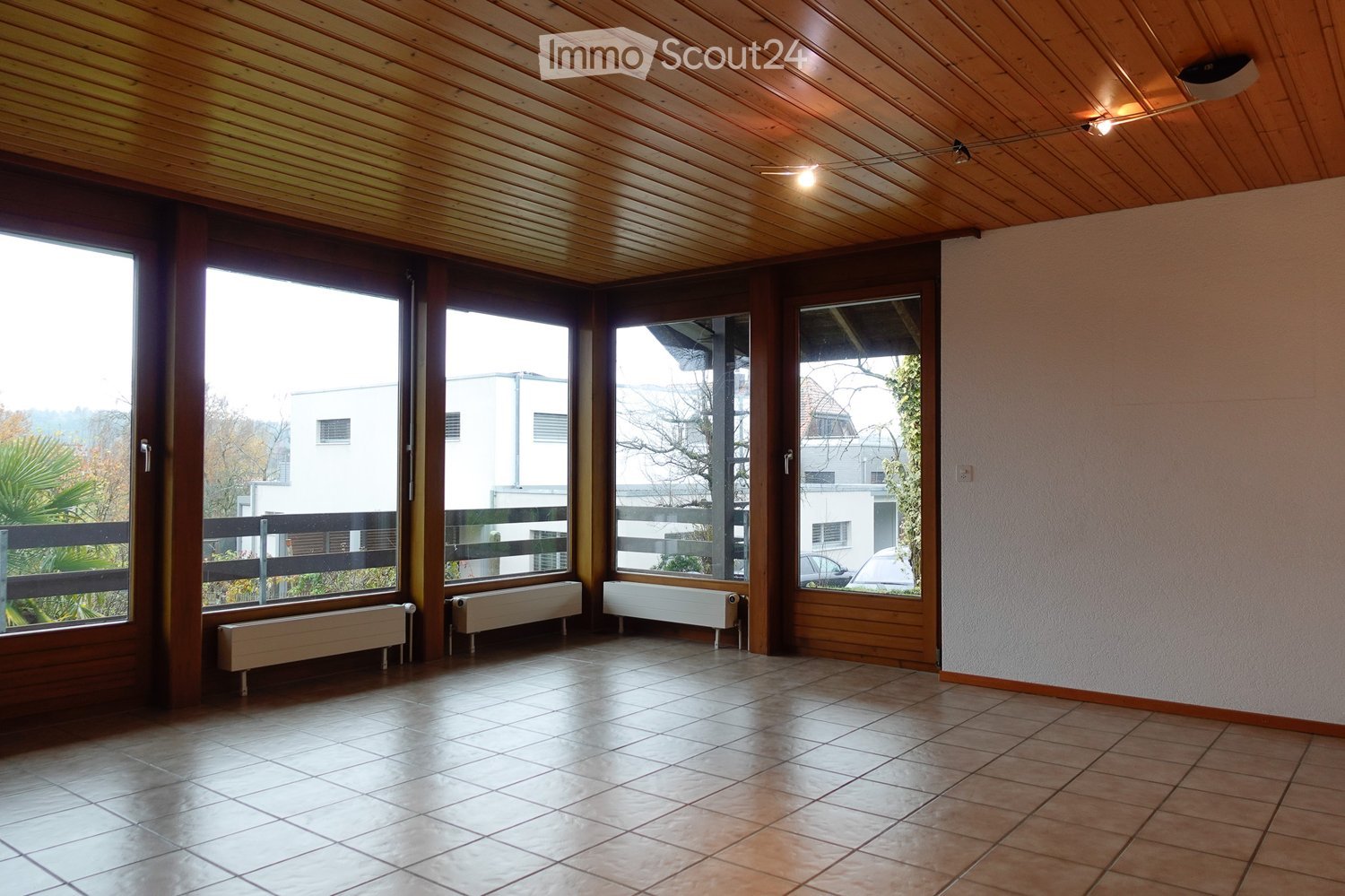 Large room with big windows, balcony, radiators, ceiling lights, empty