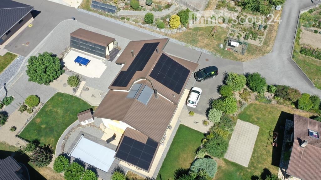 2 story house, brown roof, large garden, solar panels, driveway, 2 parked cars