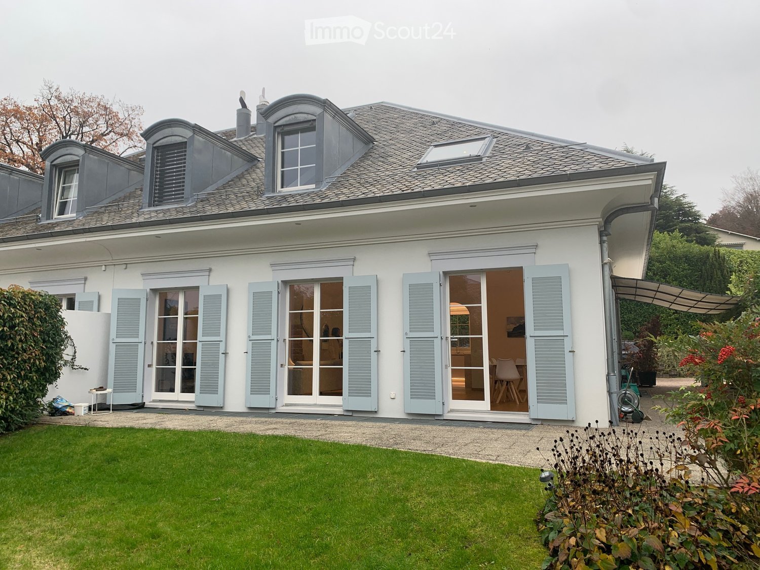 white house, gray roof, blue shutters, multiple windows, glass doors, garden, grass, pathway, awning