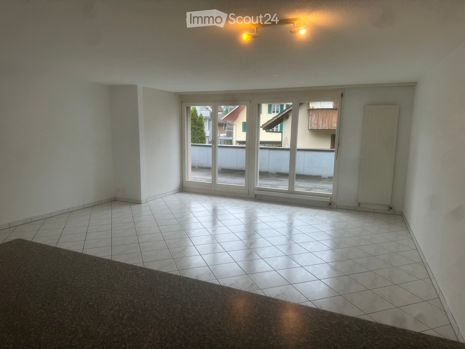 white tiles, glass doors leading to balcony, radiator