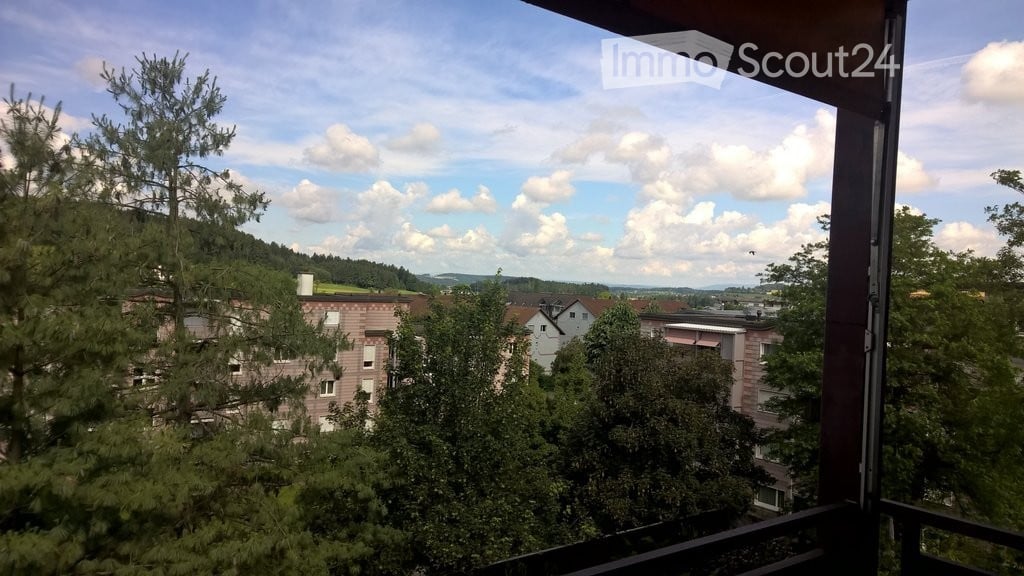 balcony with railing, overlooking the cityscape and greenery, blue sky with white clouds
