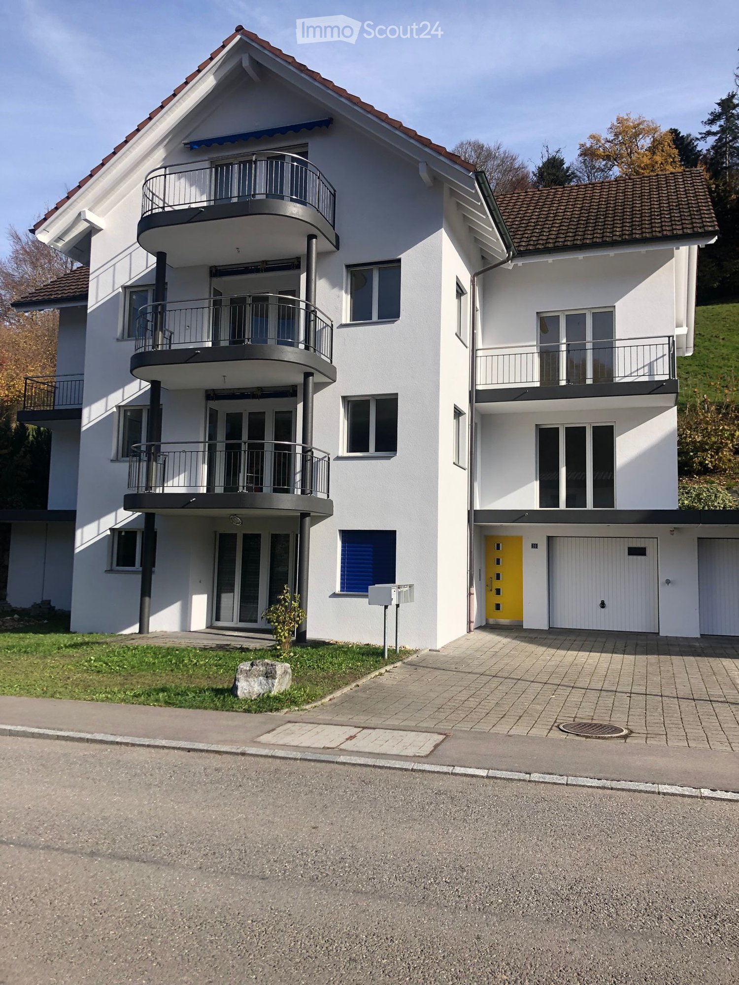 two story apartment, white exterior, balconies, two garages, driveway