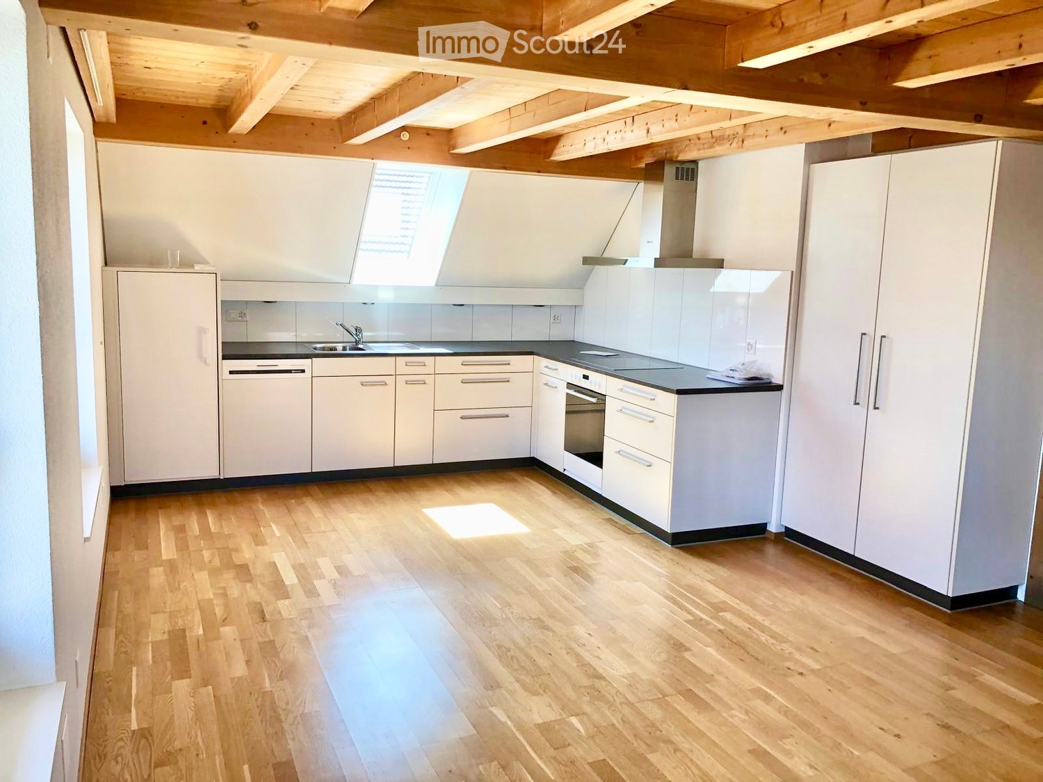 wooden ceiling, white walls, modern kitchen, white cabinets, black countertop, white oven, white sink, wooden floor