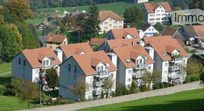 Apartment complex, multiple houses, balconies, brown roofs, green surroundings