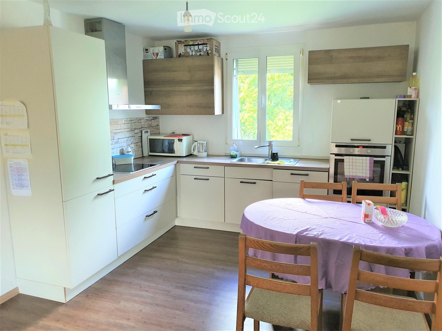 modern kitchen, white cabinets, granite countertops, sink, stainless steel appliances, microwave, dishwasher, large window with view