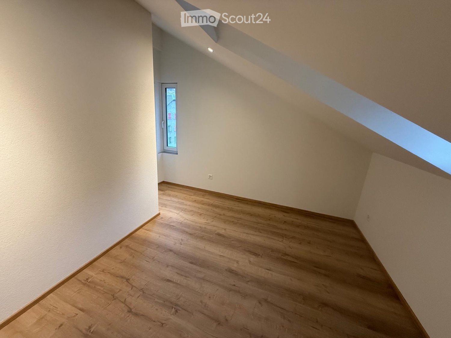 wooden floor, white walls, slanted ceiling, small window