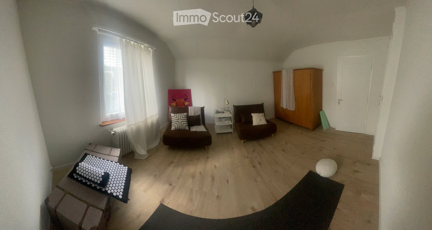 empty room with hardwood floor, two armchairs, radiator, window with curtains, shelf with lamp, wooden wardrobe