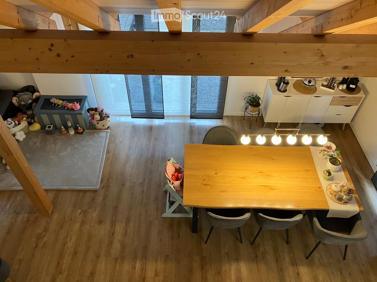 dining area with table and chairs, white kitchen, large wooden beams, windows, carpet