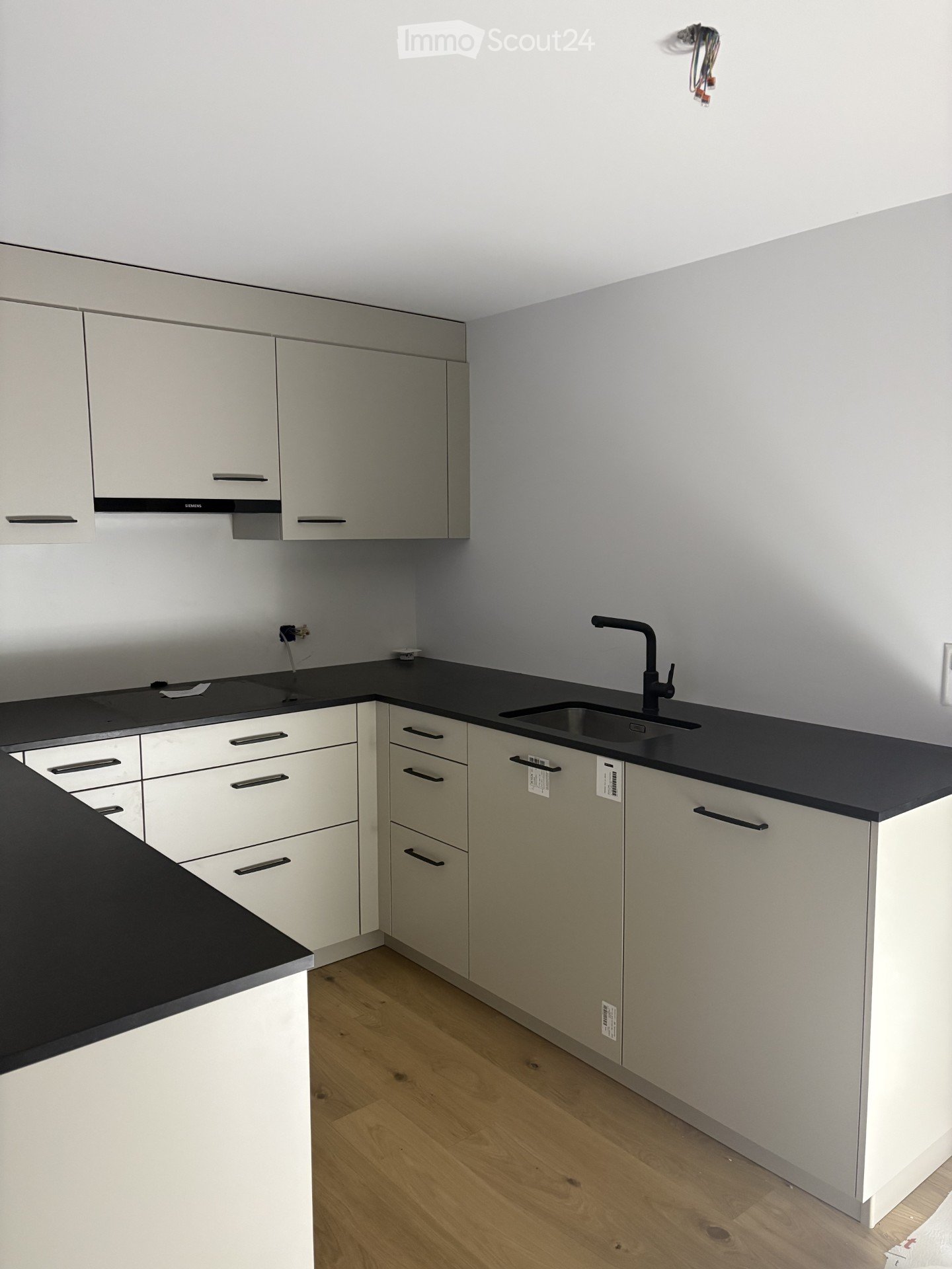 modern kitchen, white cabinets, black countertops, gray walls, sink, faucet, stovetop