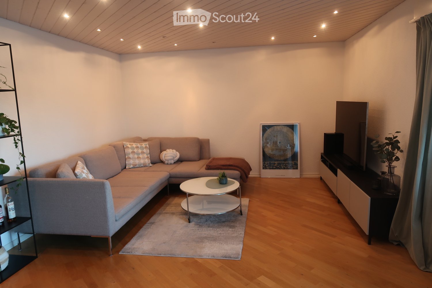Contemporary living room with sectional sofa, coffee table, TV stand, carpet, decorative items