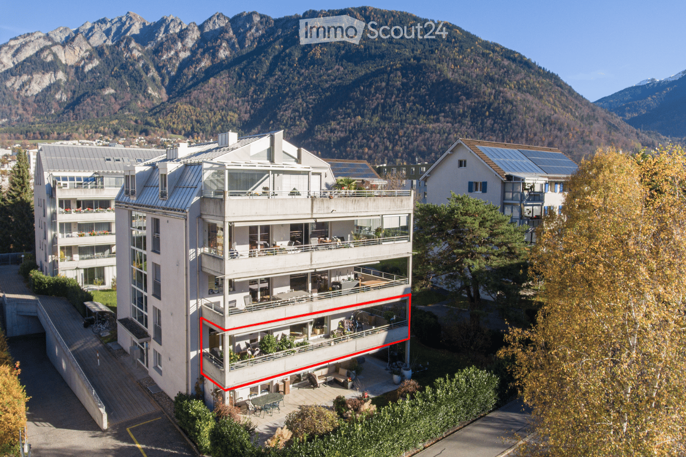 5-story apartment building with balconies and a garden, framed apartment marked in red