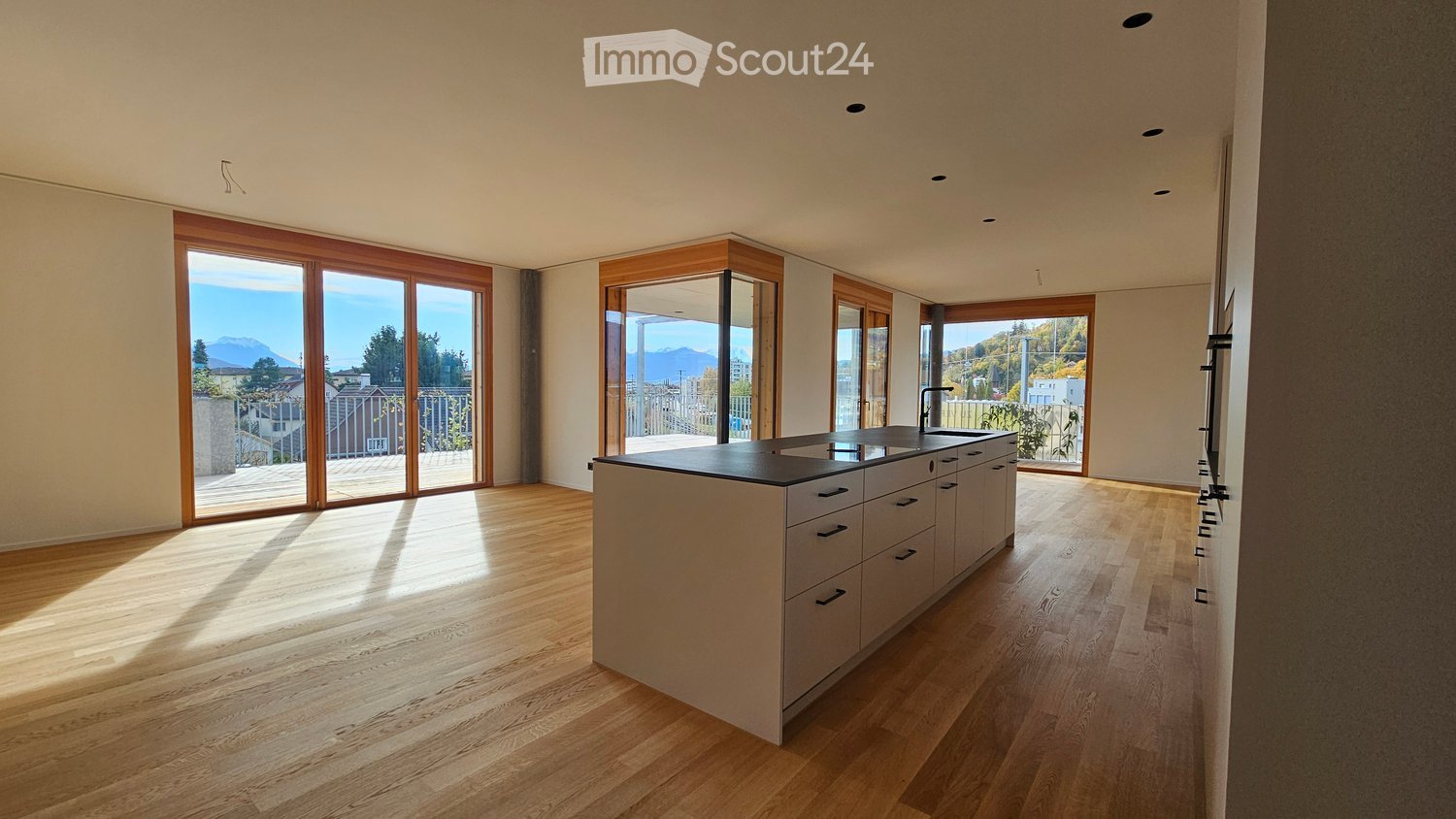 Modern kitchen, white counters, black cabinets, open balcony, large windows, wooden floor, modern lighting