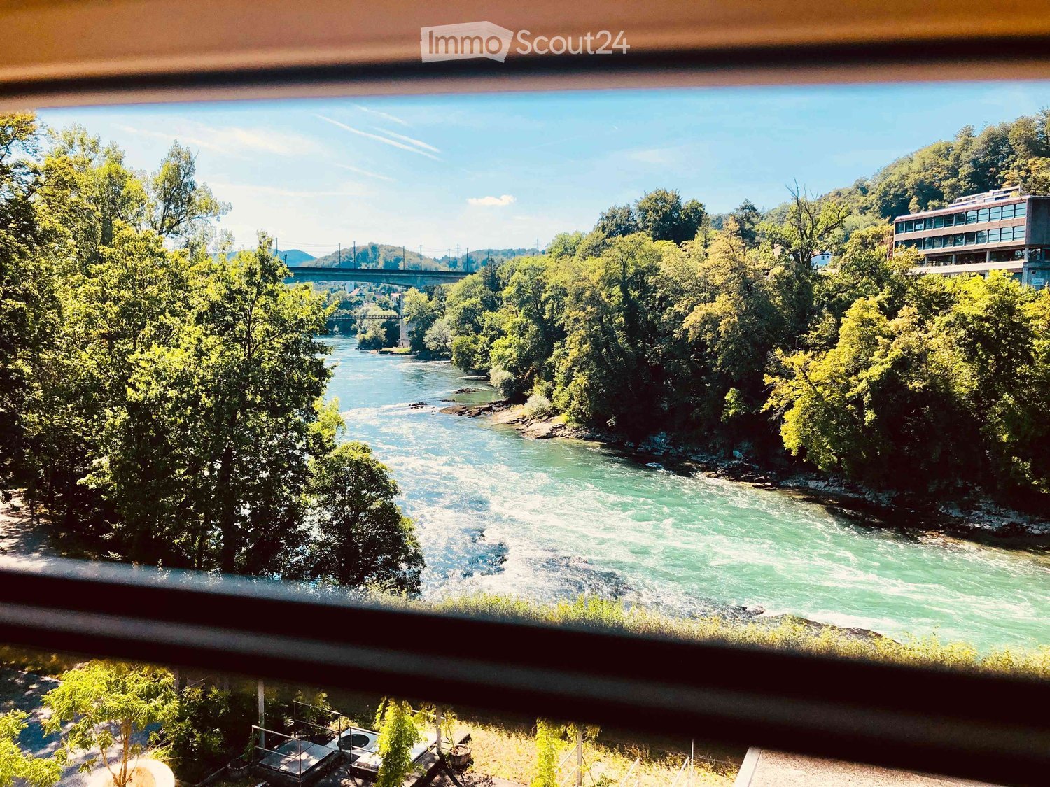 View of a river with trees and a bridge