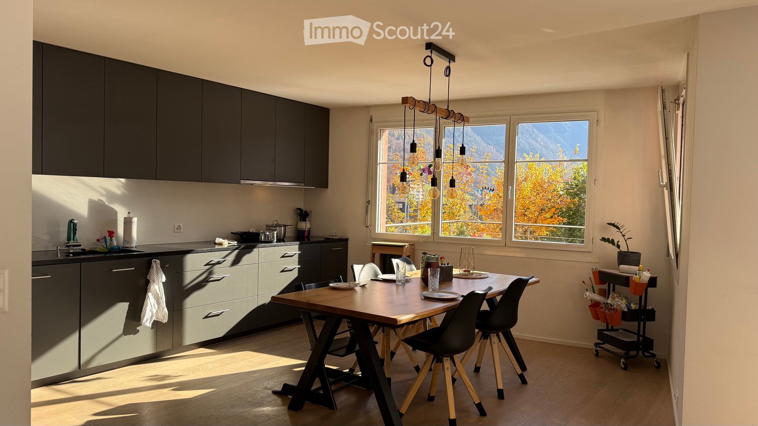 Kitchen and dining area with window that leads to a balcony.