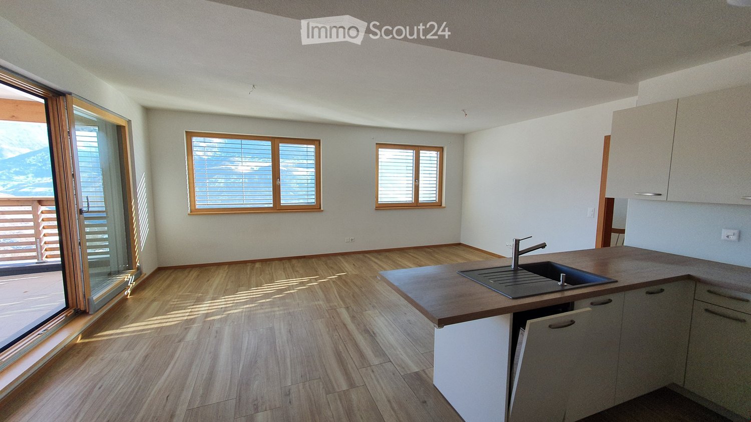 kitchen with sink, faucet, large windows, balcony with sliding glass doors, wooden floor