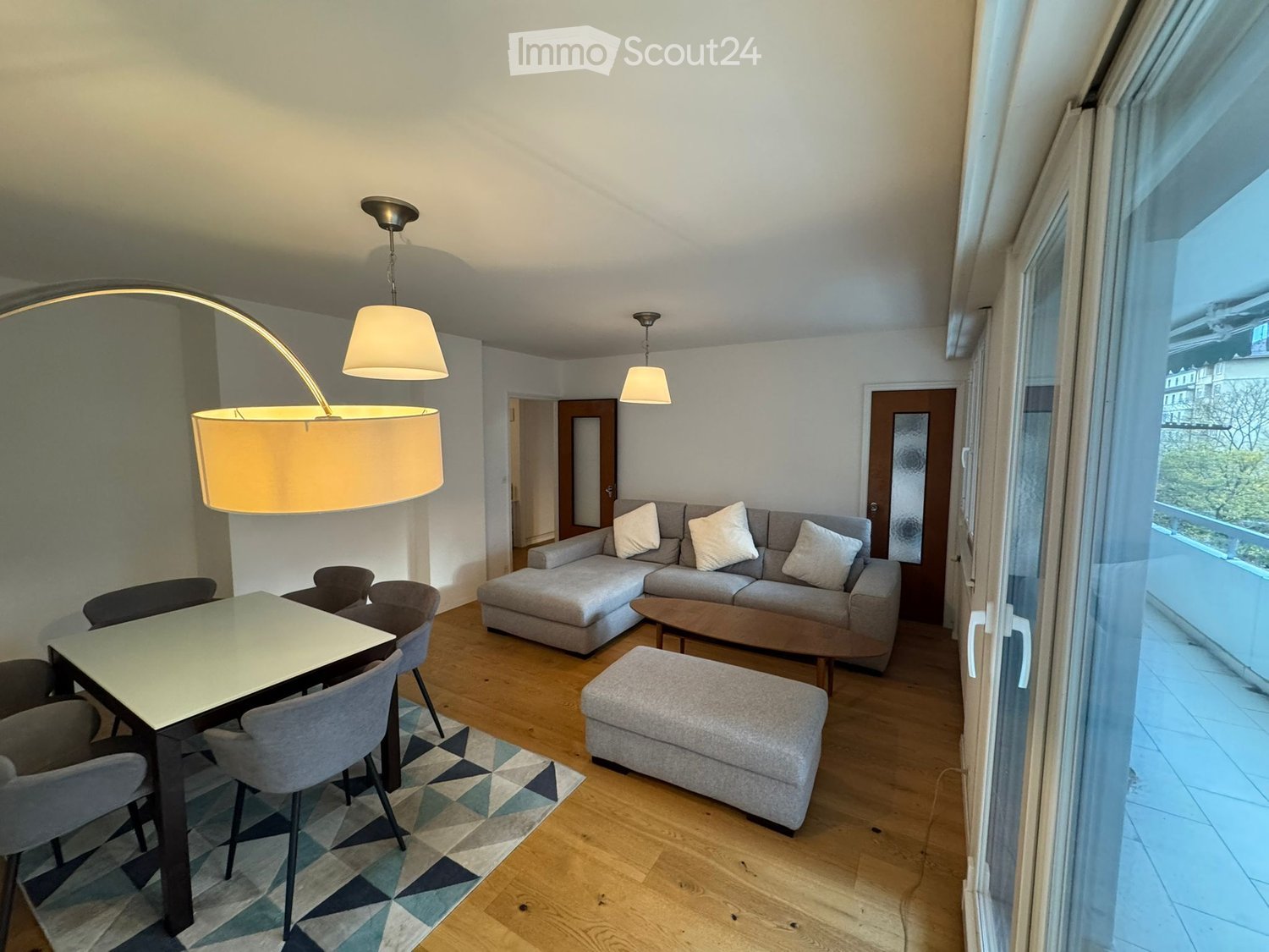 balcony, grey sectional sofa, coffee table, side table, table and chairs, lamps, rug