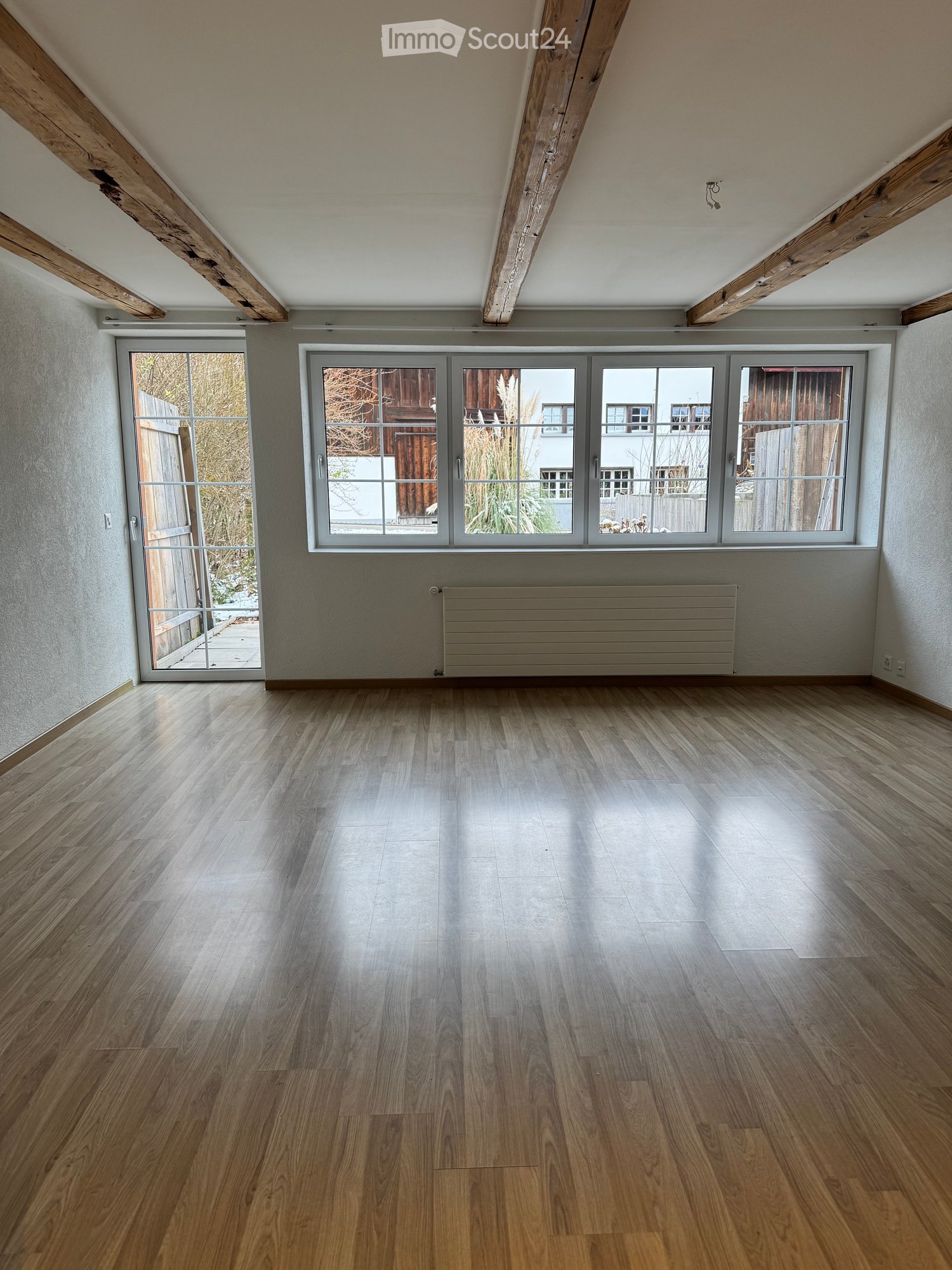 empty room, wooden flooring, wooden beams on ceiling, large windows