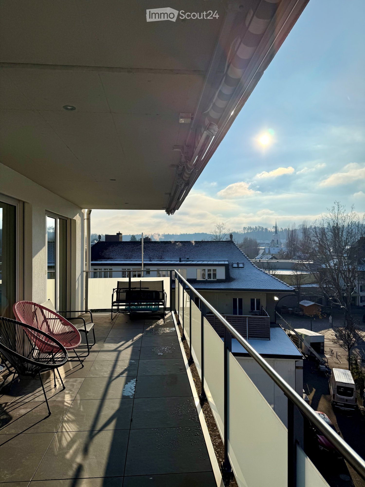 tiles floor, metal railing, 2 chairs, wooden bench, glass railing, urban view
