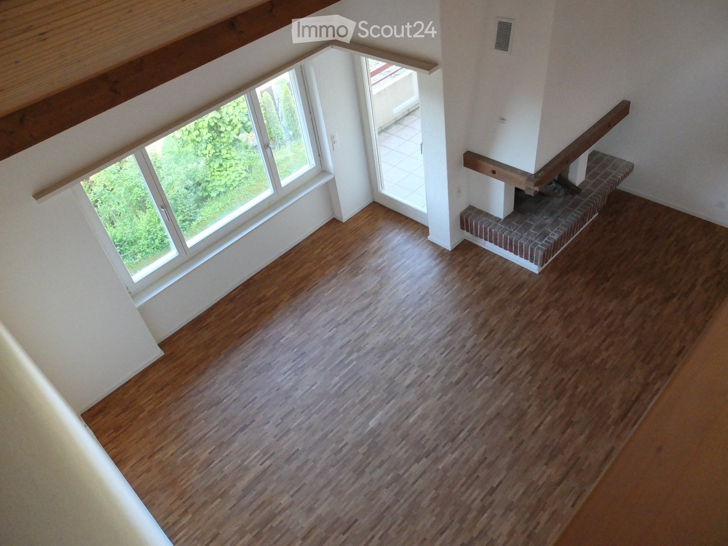 large empty room with hardwood floor, fireplace and windows