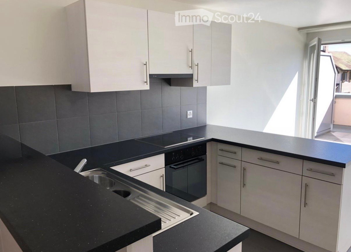 modern kitchen with white cabinetry, black granite countertop, open floor plan, gas stove, oven, and sink