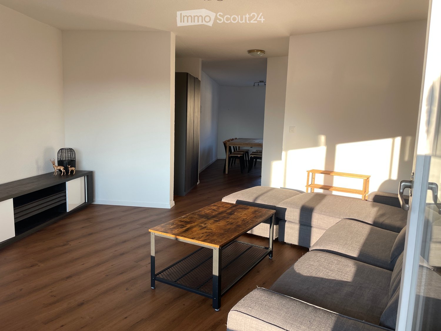 wooden floor, large couch, coffee table, sliding door