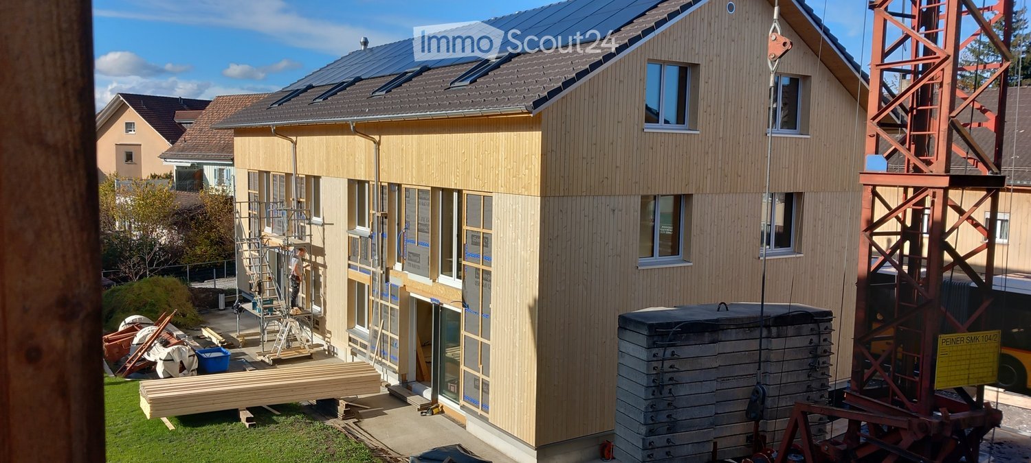 Modern house, brown wooden walls, roof solar panels, under construction