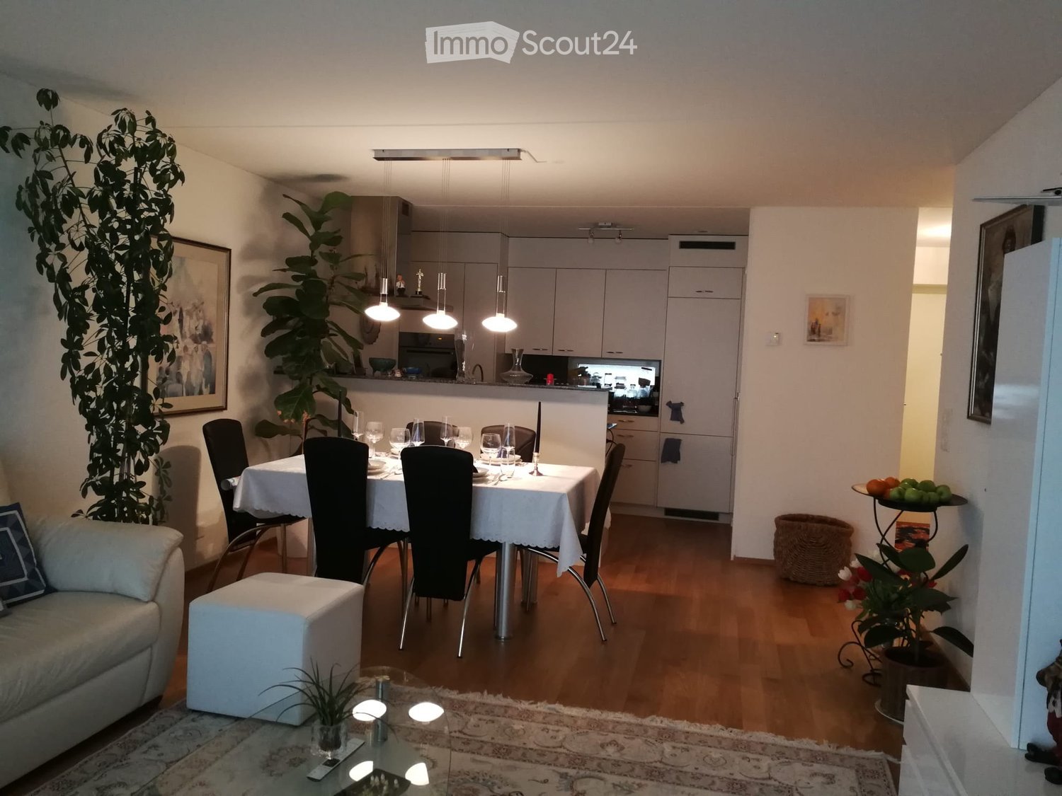 4 black chairs, large table, 1 white sofa, carpet, lamps, large windows