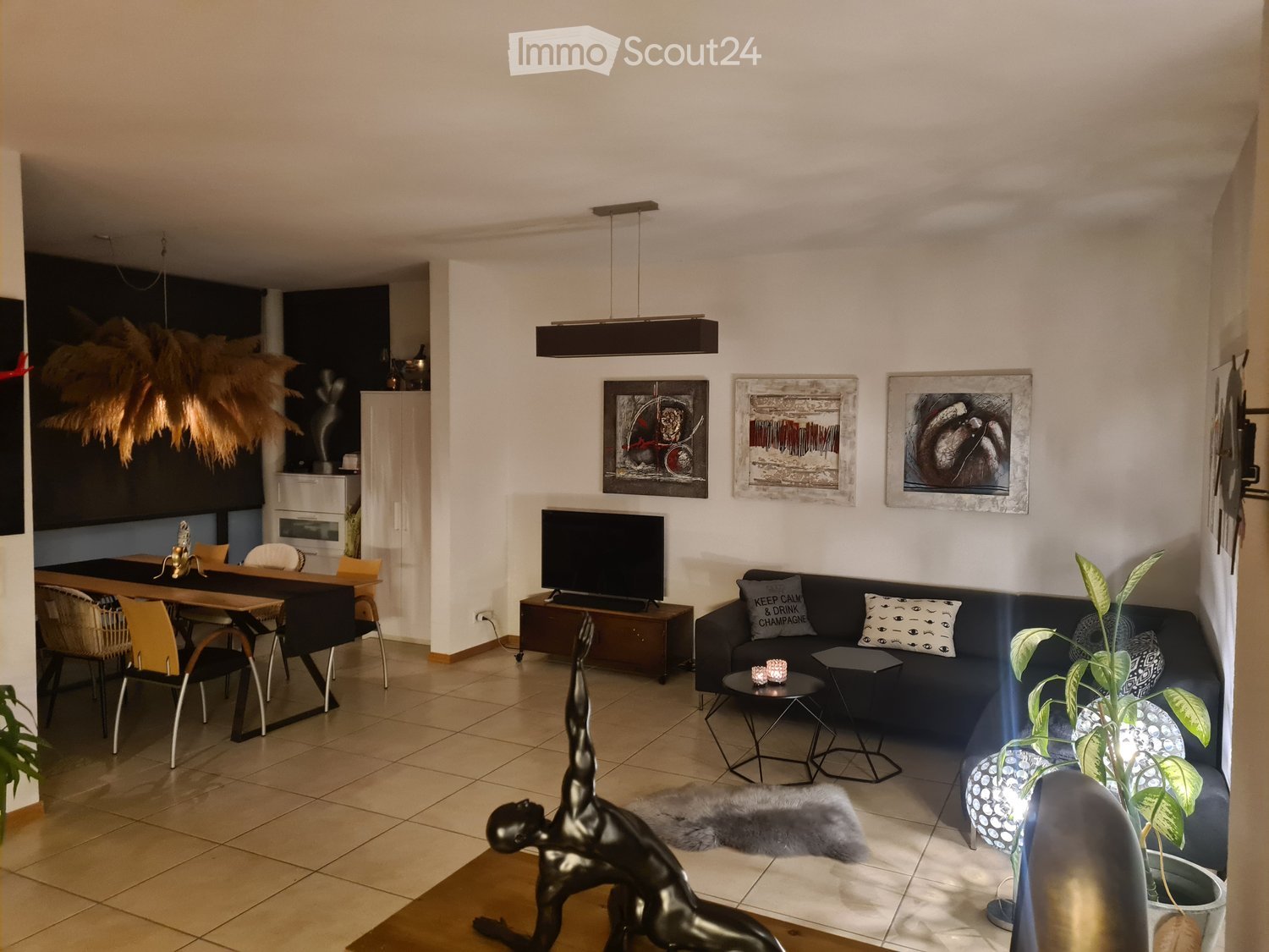 Dining table with chairs, couch, TV, art frames, statue, lamps, potted plants, rug, wall art, power outlet