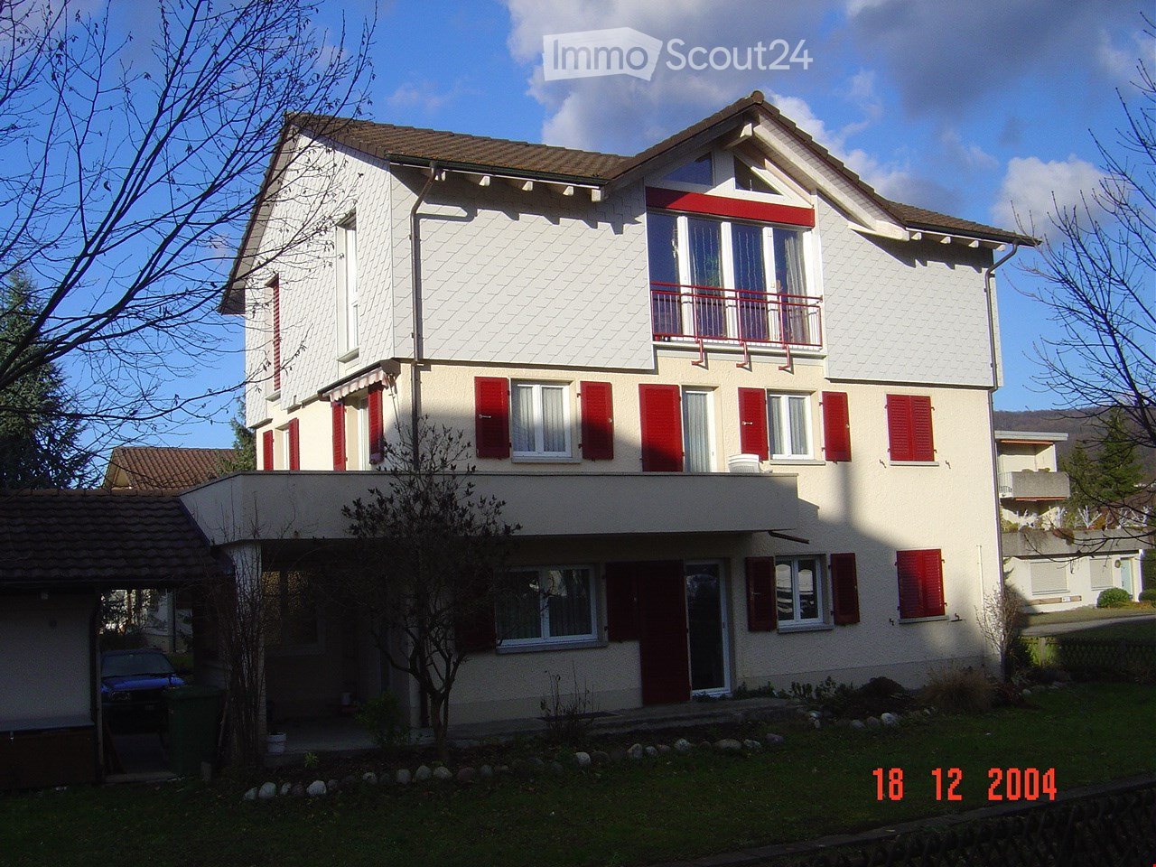 2 story house, white painted exterior, red shutters, balcony, car parked in garage