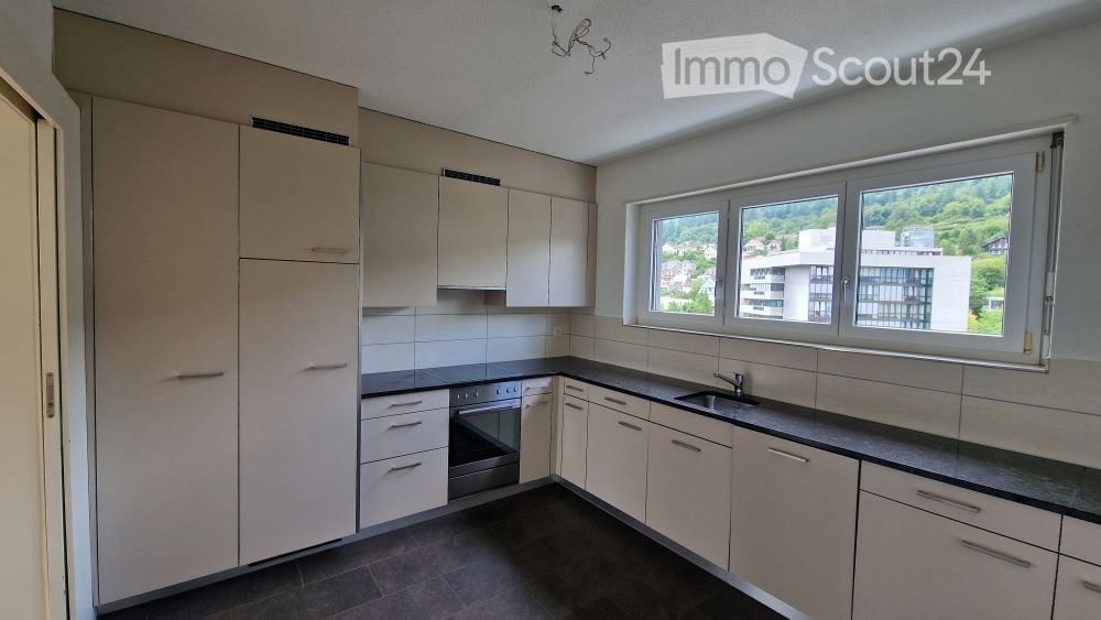 white cabinets, black countertops, white tiled wall, stainless steel appliances, white refrigerator, sink, built-in oven, dishwasher, washing machine