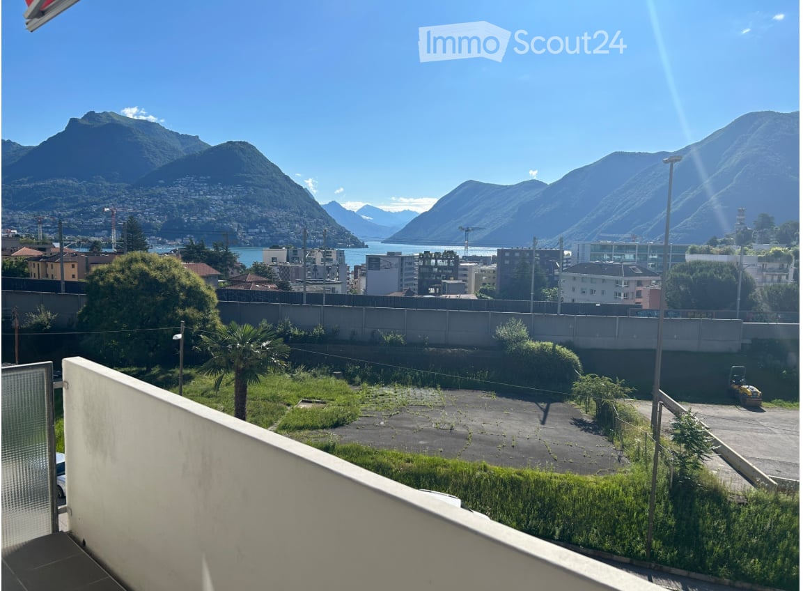 elevated view with balcony railing, mountains, city, lake