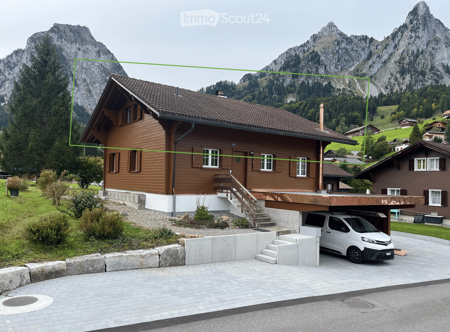 Brown wooden house, brown roof, white windows, concrete garage with a car parked inside
