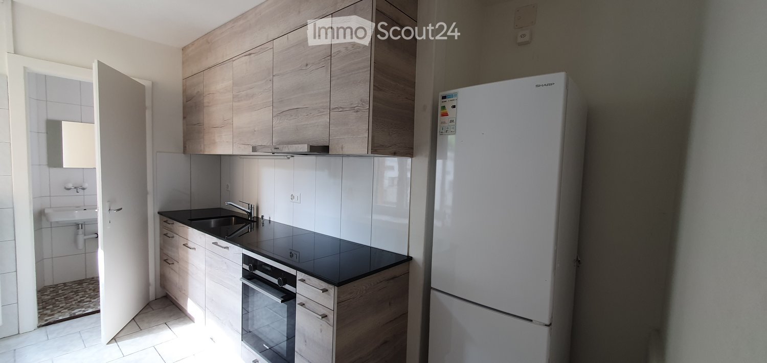 modern kitchen, white tiles, wooden cabinets, black countertops, stainless steel sink, dishwasher, washing machine, white refrigerator