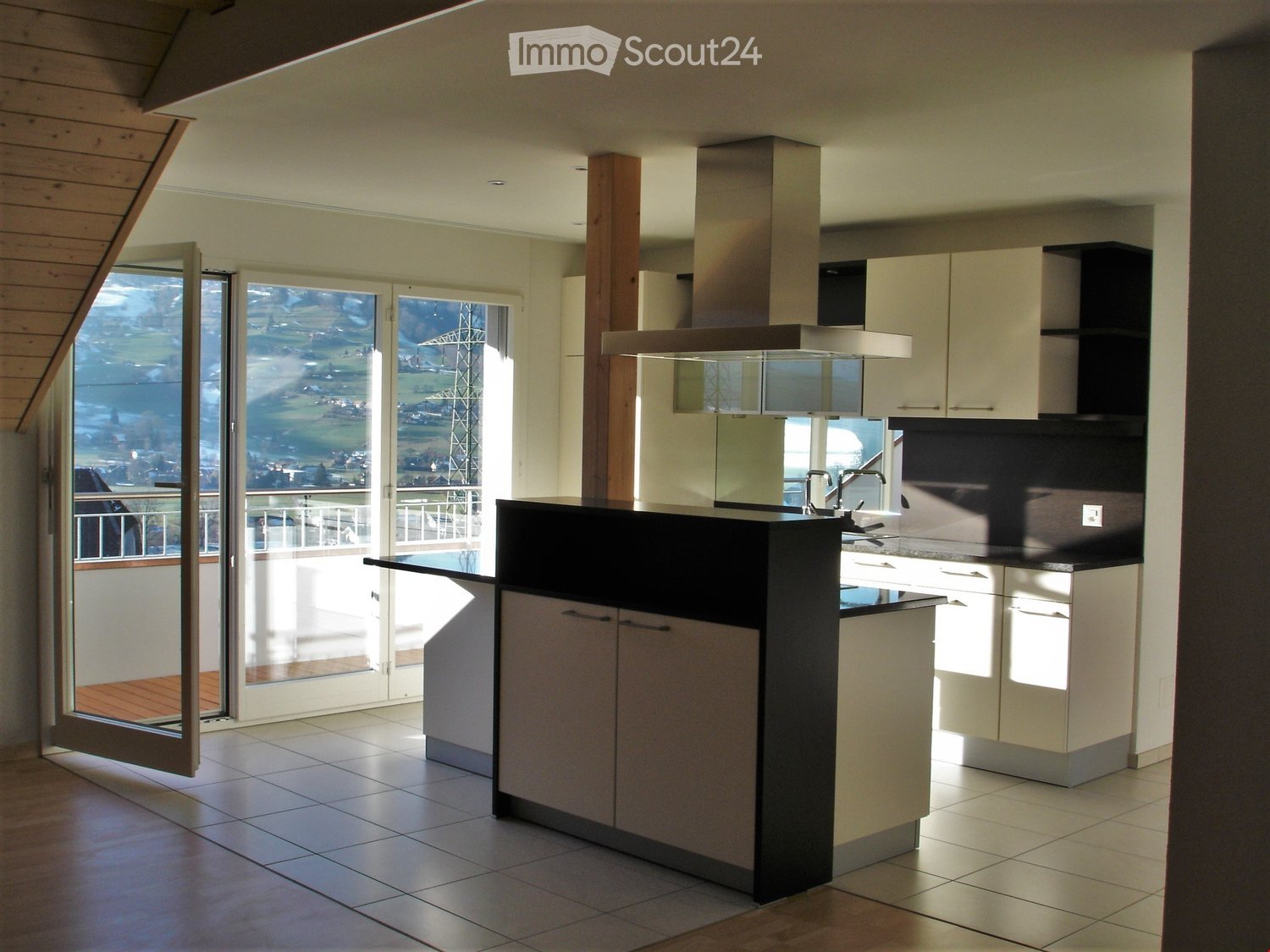 modern kitchen, black countertops, white cabinets, open balcony, glass doors, metal railing, balcony floor