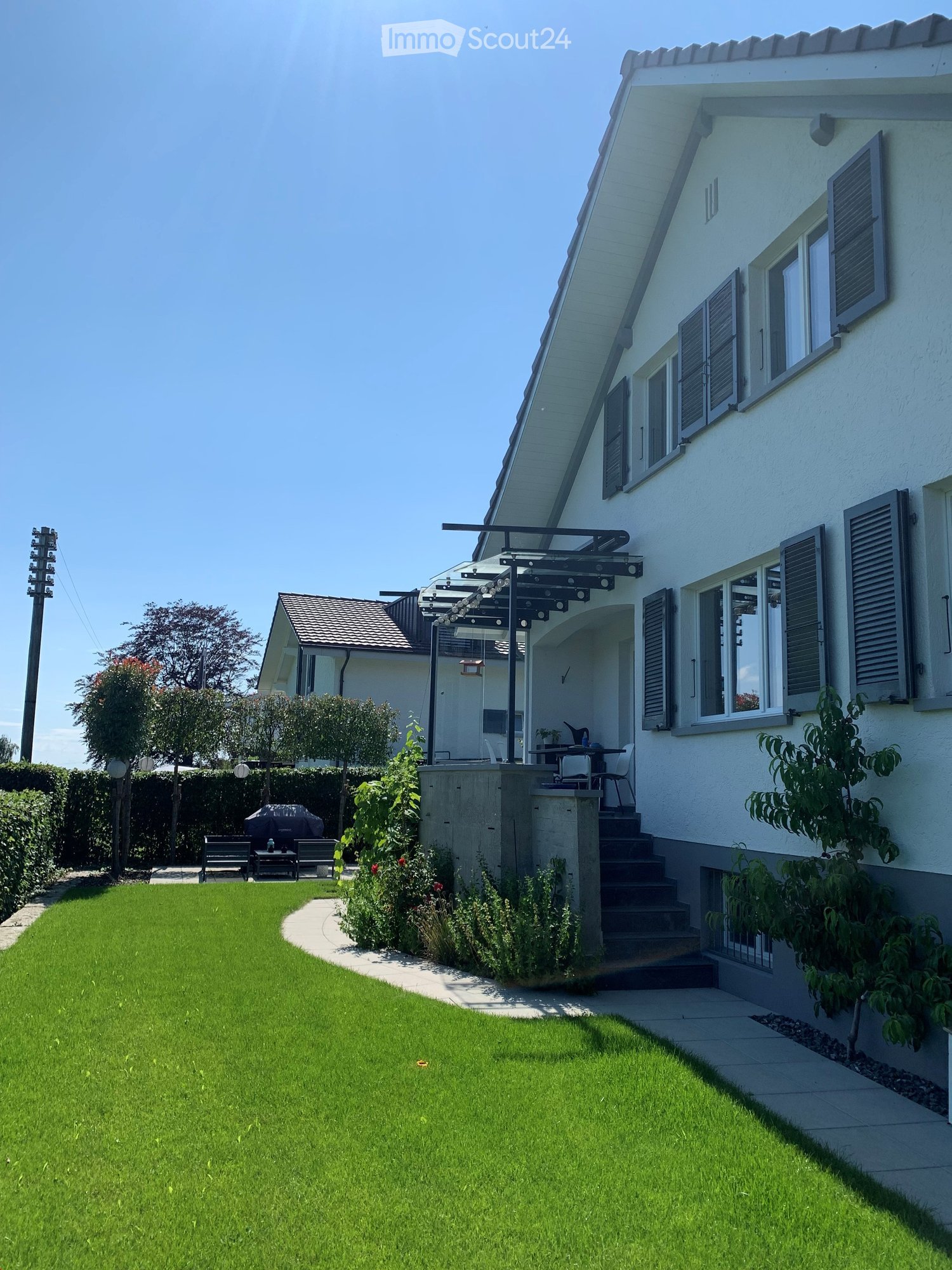Two story house, white paint, wooden terrace, raised ground floor, garden