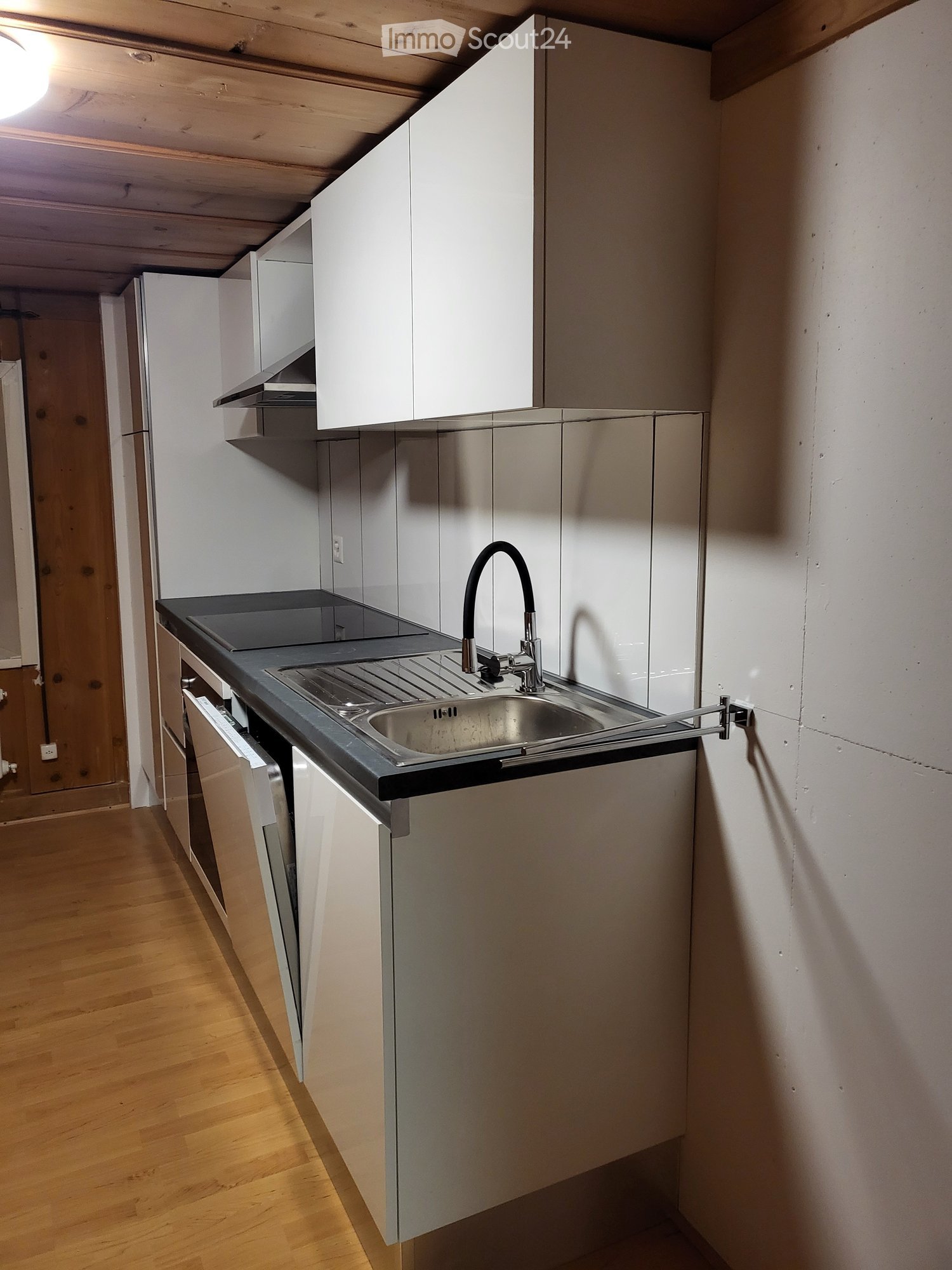 white kitchen cabinets, stainless steel countertop, modern sink with faucet, wooden flooring, stainless steel oven