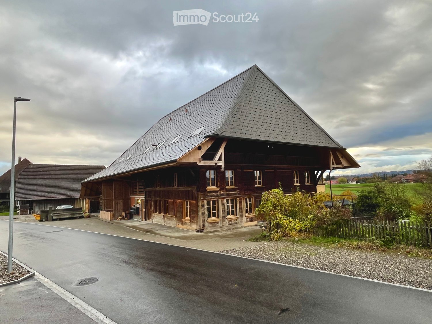 Large timber-frame house, slate roof, windows, driveway in front