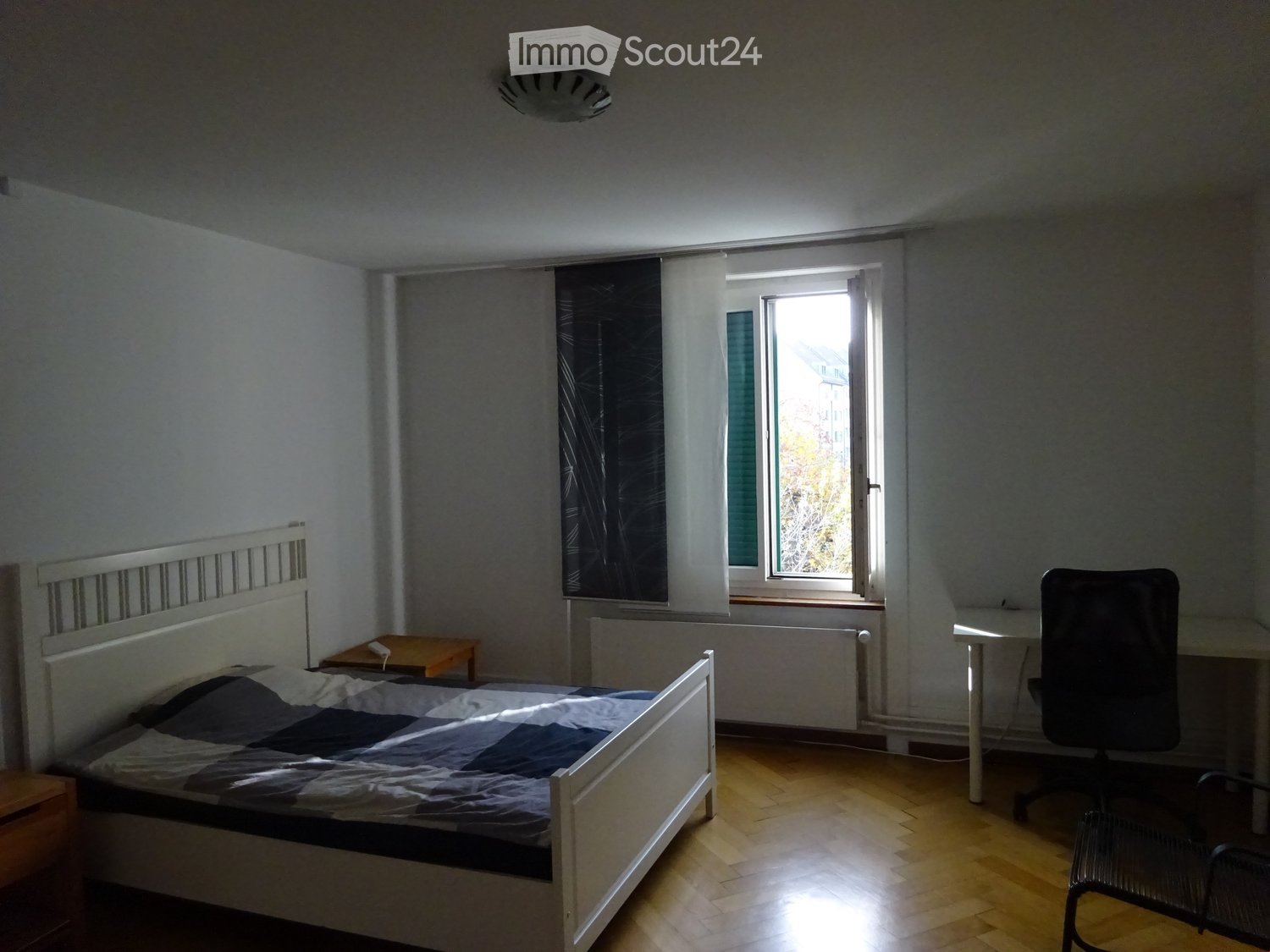 Bed in room, desk and chair, window with curtains