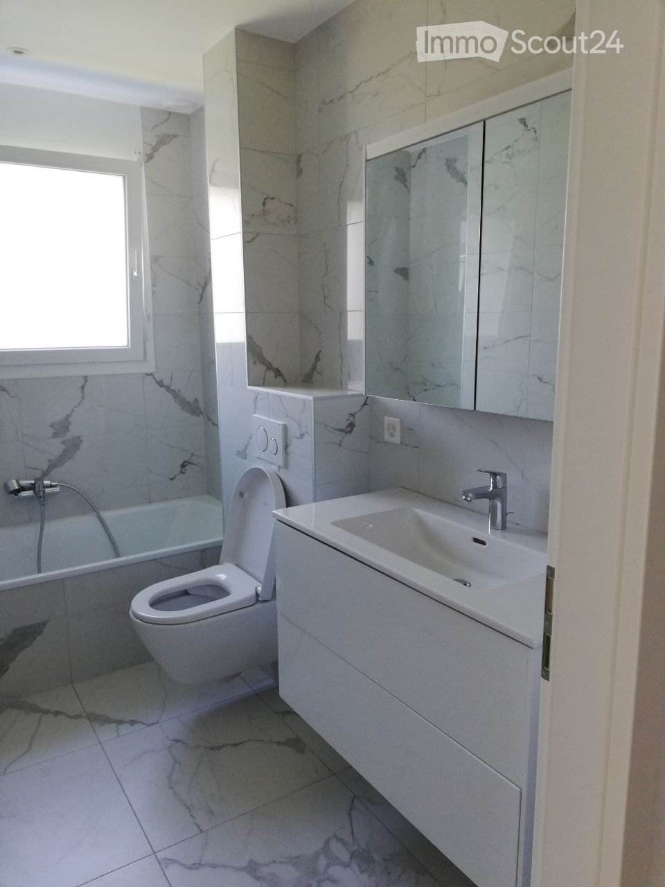 white marble bathroom, toilet, bathtub, sink, mirror, wall tiles, window