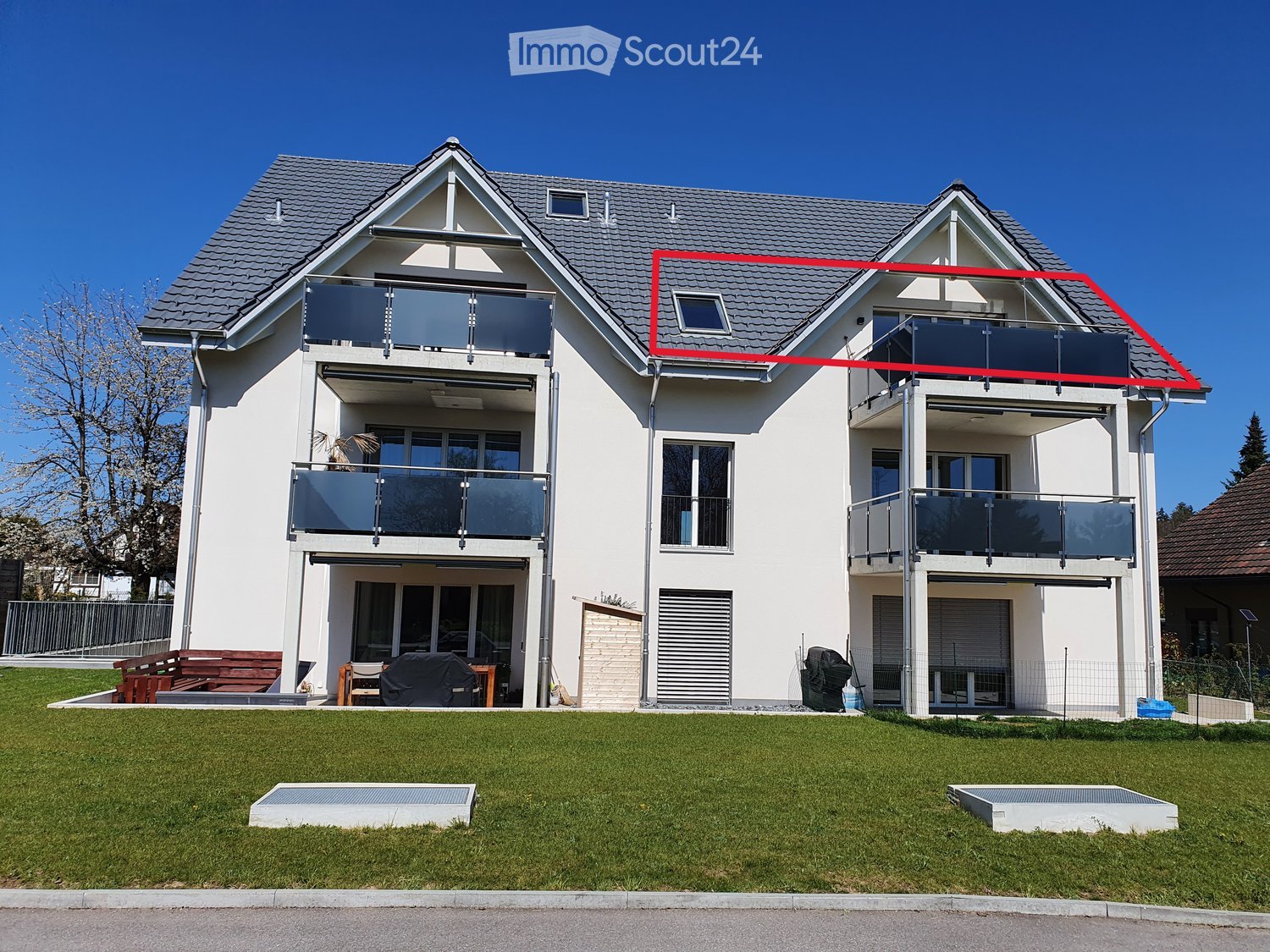 Two-story white house, gray roof, multiple balconies, fenced garden